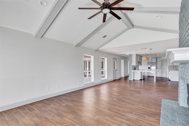 unfurnished living room featuring ceiling fan, lofted ceiling with beams, and a brick fireplace