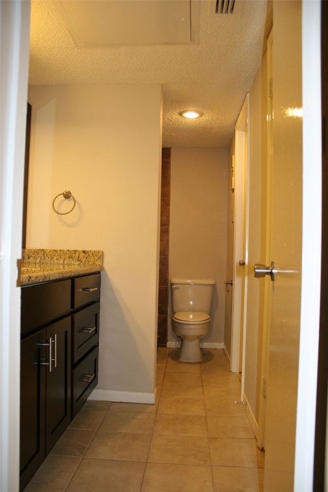 bathroom with vanity, tile patterned flooring, a textured ceiling, and toilet