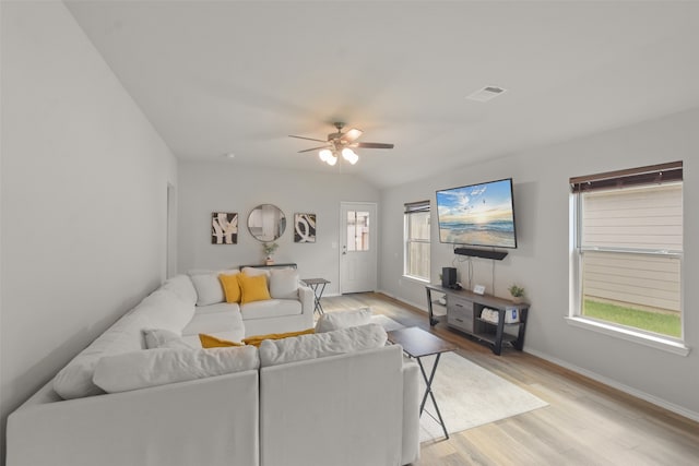 living room with light hardwood / wood-style floors, ceiling fan, and lofted ceiling