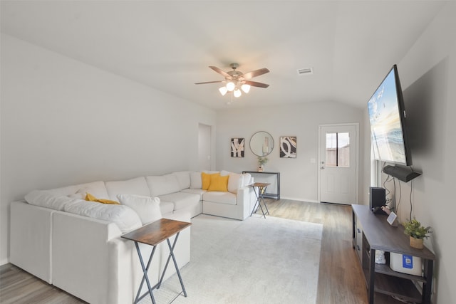 living room with ceiling fan, light wood-type flooring, and vaulted ceiling