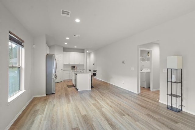 kitchen with white cabinets, a healthy amount of sunlight, stainless steel appliances, and a kitchen island