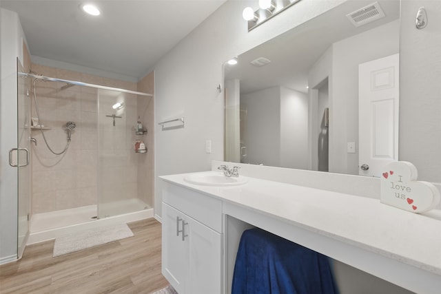 bathroom with vanity, hardwood / wood-style floors, and a shower with shower door