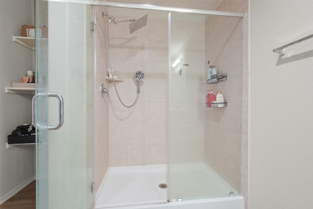 bathroom featuring hardwood / wood-style flooring and a shower with door