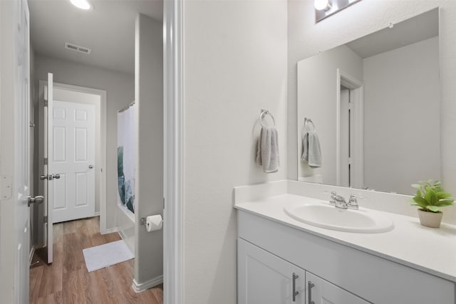 bathroom with vanity, hardwood / wood-style floors, and shower / bathtub combination with curtain