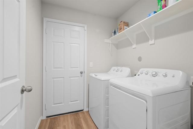 washroom with light wood-type flooring and washer and dryer