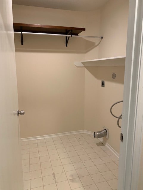 laundry room featuring electric dryer hookup and light tile patterned floors