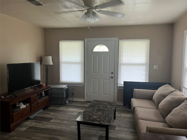 living room featuring dark wood-type flooring and ceiling fan