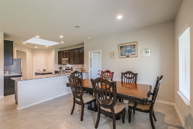 dining space with a wealth of natural light and a skylight