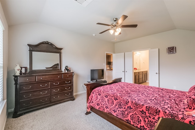 bedroom with lofted ceiling, light colored carpet, connected bathroom, and ceiling fan