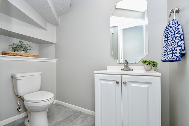 bathroom with hardwood / wood-style floors, vanity, toilet, and a textured ceiling