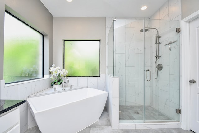 bathroom featuring shower with separate bathtub and vanity