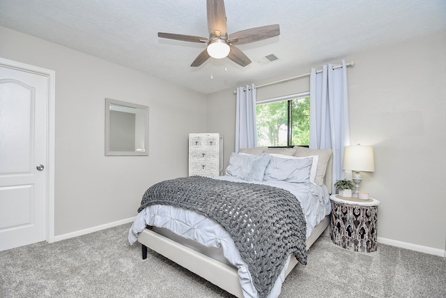 bedroom with carpet, ceiling fan, and a textured ceiling