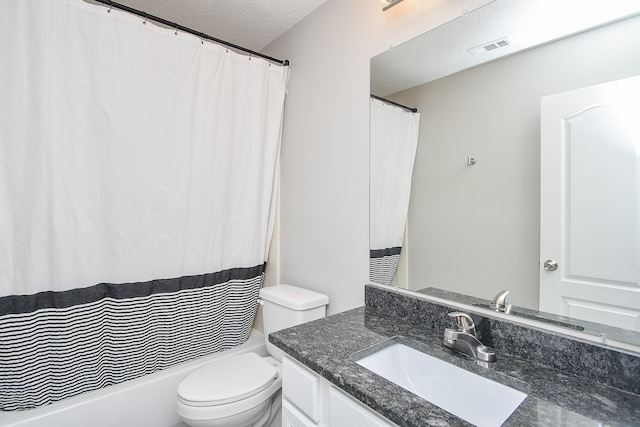 bathroom with vanity, toilet, and a textured ceiling