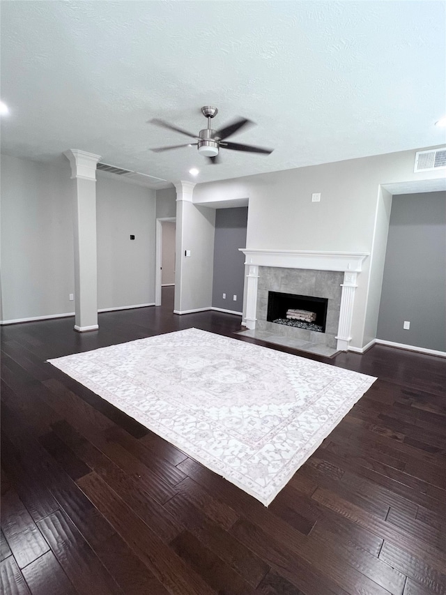 unfurnished living room featuring ceiling fan, dark hardwood / wood-style flooring, and a fireplace