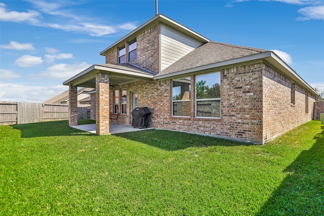 rear view of property featuring a lawn and a patio