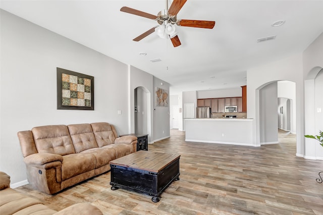 living room with light hardwood / wood-style flooring and ceiling fan