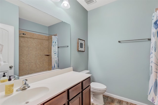 bathroom featuring toilet, vanity, wood-type flooring, and walk in shower