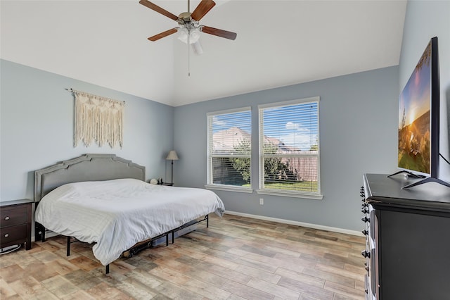 bedroom featuring ceiling fan, light wood-type flooring, and high vaulted ceiling