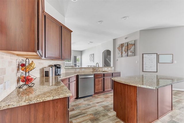 kitchen with light hardwood / wood-style floors, sink, kitchen peninsula, light stone counters, and dishwasher