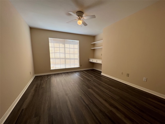 unfurnished living room with dark hardwood / wood-style flooring, built in desk, and ceiling fan