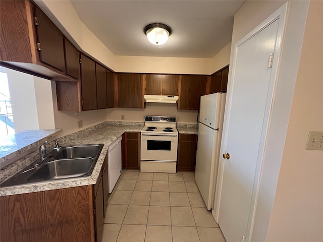 kitchen with light tile patterned floors, white appliances, sink, and dark brown cabinetry