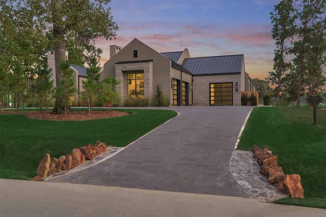 view of front of home featuring a garage and a lawn