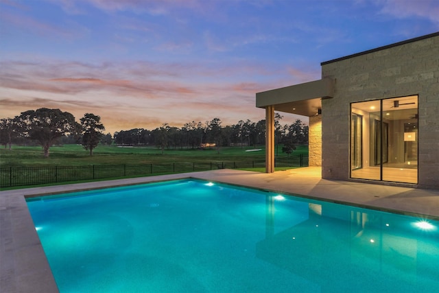 pool at dusk featuring a patio area