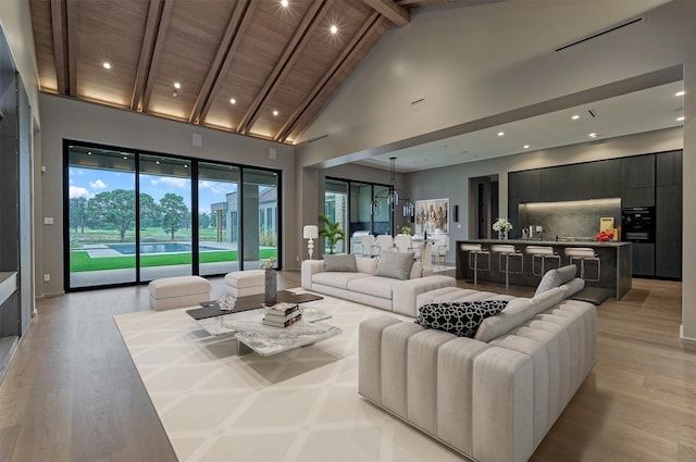 living room with high vaulted ceiling, light hardwood / wood-style flooring, beamed ceiling, and wooden ceiling