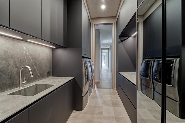 kitchen featuring gray cabinetry, washer and clothes dryer, sink, and backsplash