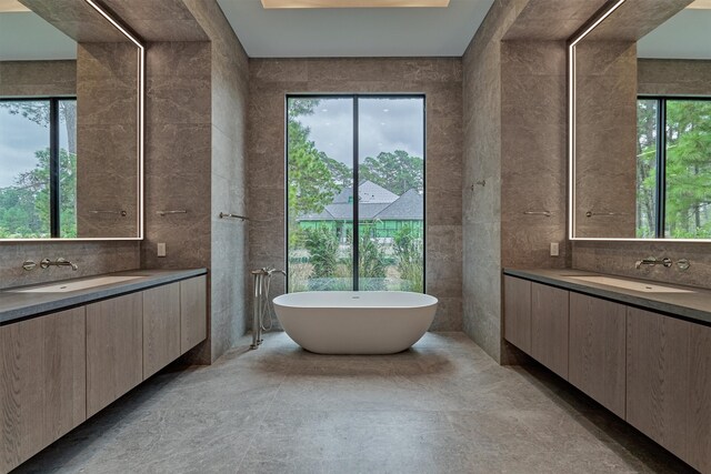 bathroom featuring a wealth of natural light, tile walls, and a bathing tub