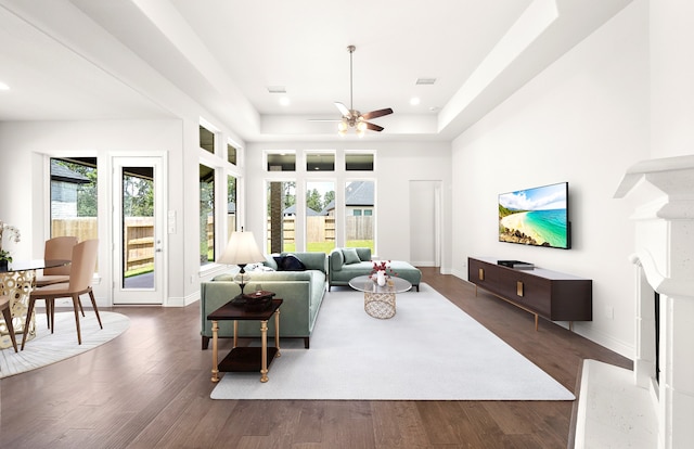 living room featuring a wealth of natural light, ceiling fan, and dark hardwood / wood-style flooring