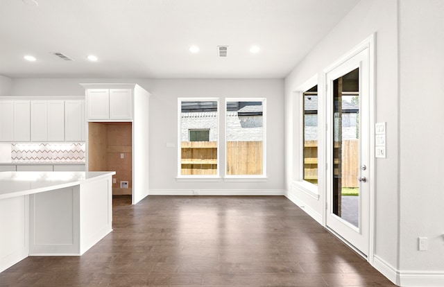 kitchen featuring white cabinetry, decorative backsplash, and dark hardwood / wood-style flooring