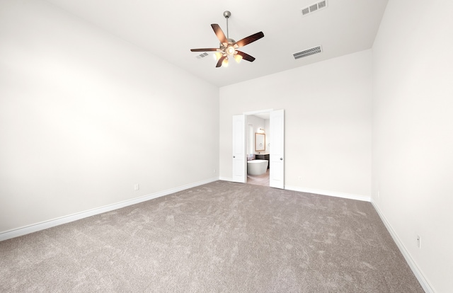 unfurnished bedroom with ensuite bathroom, carpet, lofted ceiling, and ceiling fan