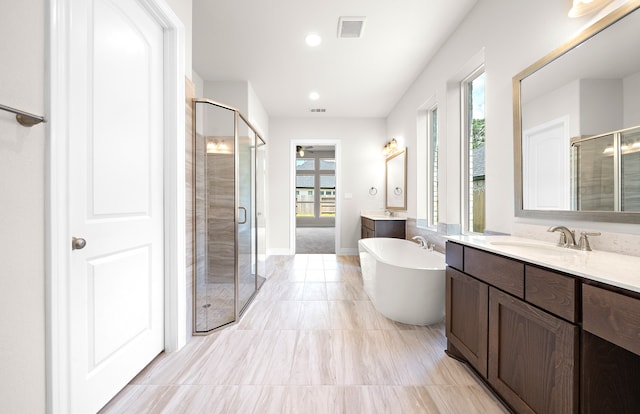 bathroom with independent shower and bath, vanity, and plenty of natural light