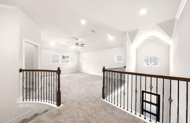 corridor featuring lofted ceiling, light colored carpet, and crown molding