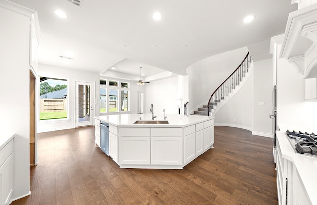 kitchen with a kitchen island with sink, dark hardwood / wood-style flooring, sink, and white cabinets