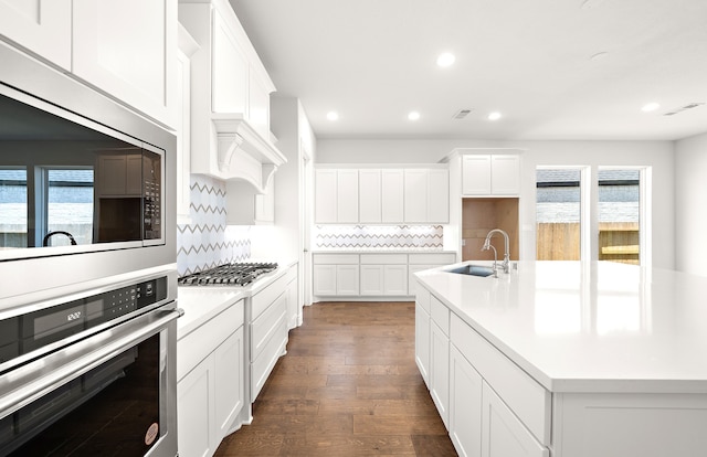 kitchen with white cabinetry, sink, appliances with stainless steel finishes, dark hardwood / wood-style floors, and decorative backsplash