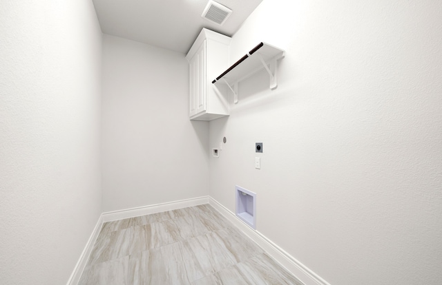 clothes washing area featuring cabinets, hookup for a gas dryer, and hookup for an electric dryer