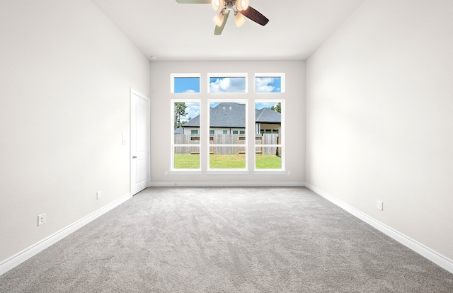 carpeted spare room with ceiling fan