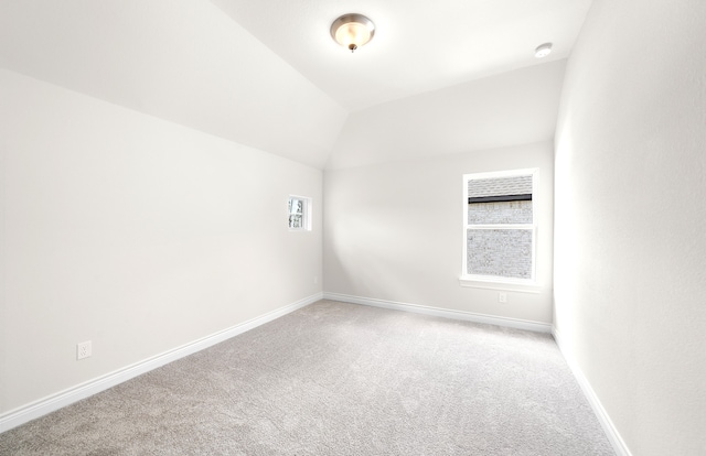 spare room with carpet flooring and lofted ceiling