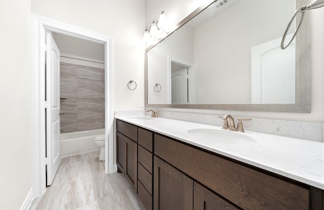 full bathroom with toilet, vanity, and tiled shower / bath