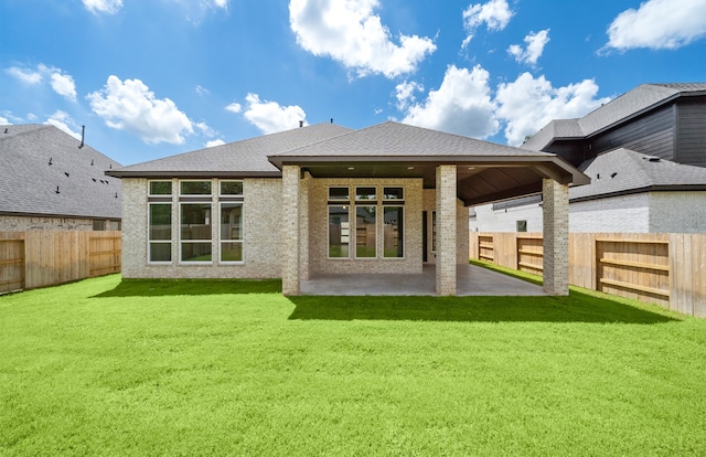 rear view of property featuring a patio area and a yard