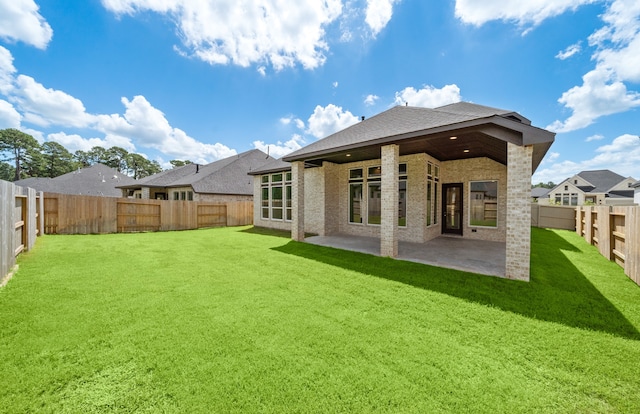 rear view of property with a lawn and a patio area