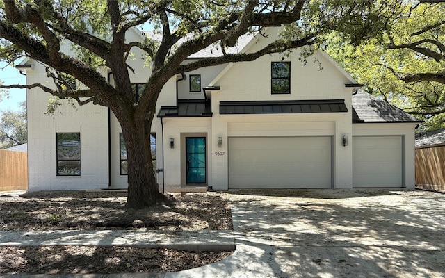 view of front of house with concrete driveway, brick siding, fence, and a garage