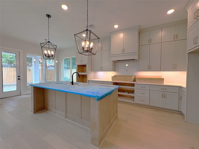 kitchen with backsplash, an inviting chandelier, visible vents, and light wood-style flooring