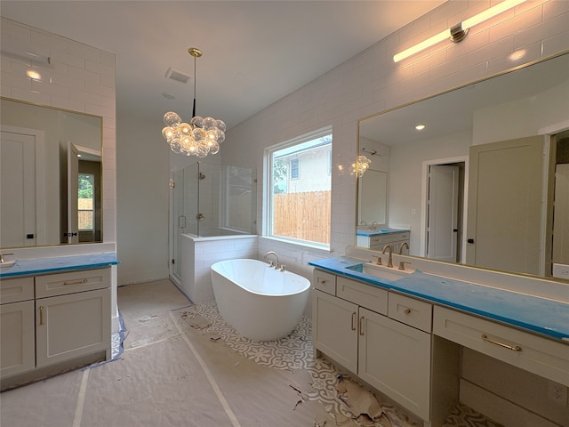 full bathroom featuring a sink, a stall shower, a freestanding tub, an inviting chandelier, and visible vents