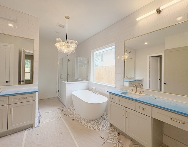 9607 Kerrwood Ln, Houston, TX 77080 - bathroom with a shower stall, a freestanding bath, a chandelier, and two vanities