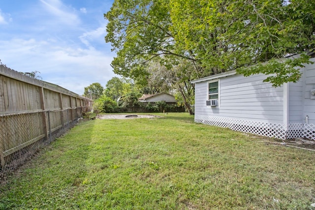 view of yard featuring cooling unit and a fire pit