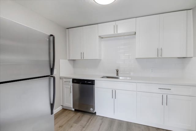 kitchen featuring white cabinets, sink, light hardwood / wood-style flooring, and appliances with stainless steel finishes