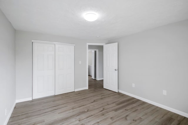 unfurnished bedroom featuring a closet and light hardwood / wood-style floors